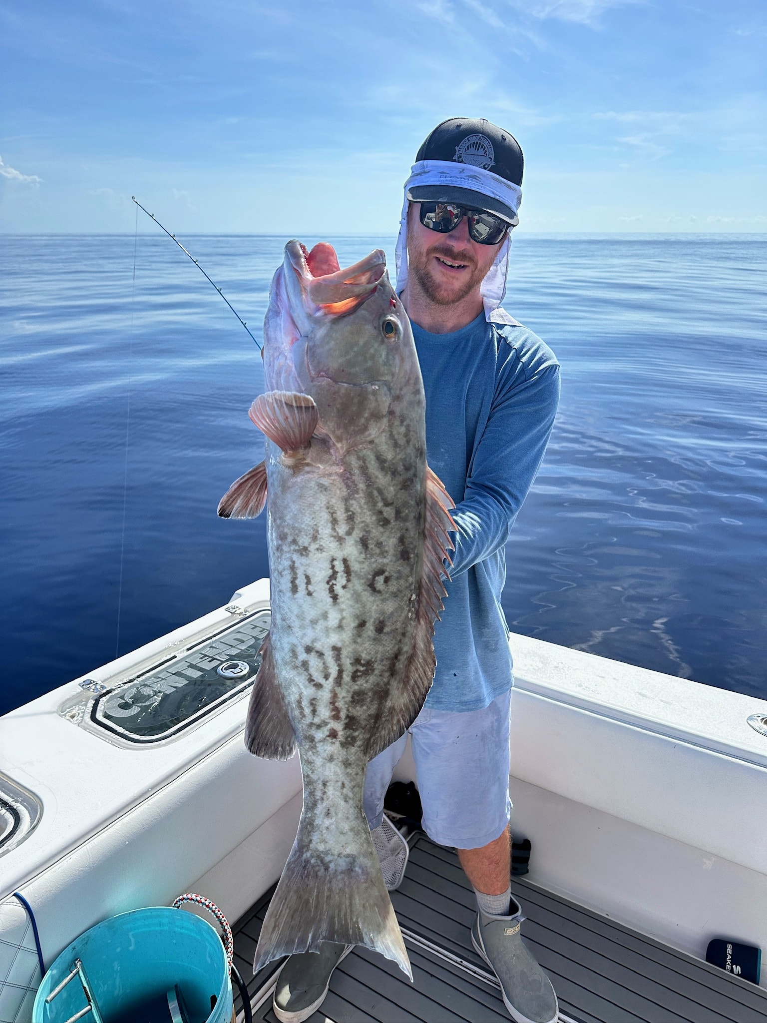 Angler holding a heavy gag grouper offshore