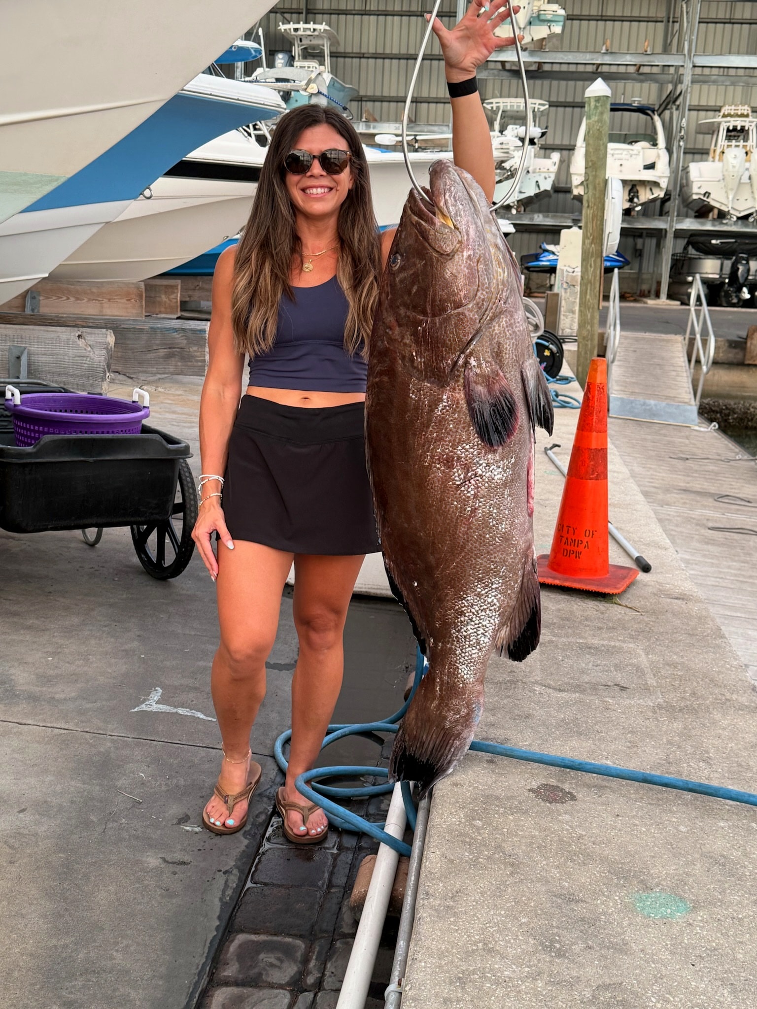 An angler on the dock with a heavy gag grouper