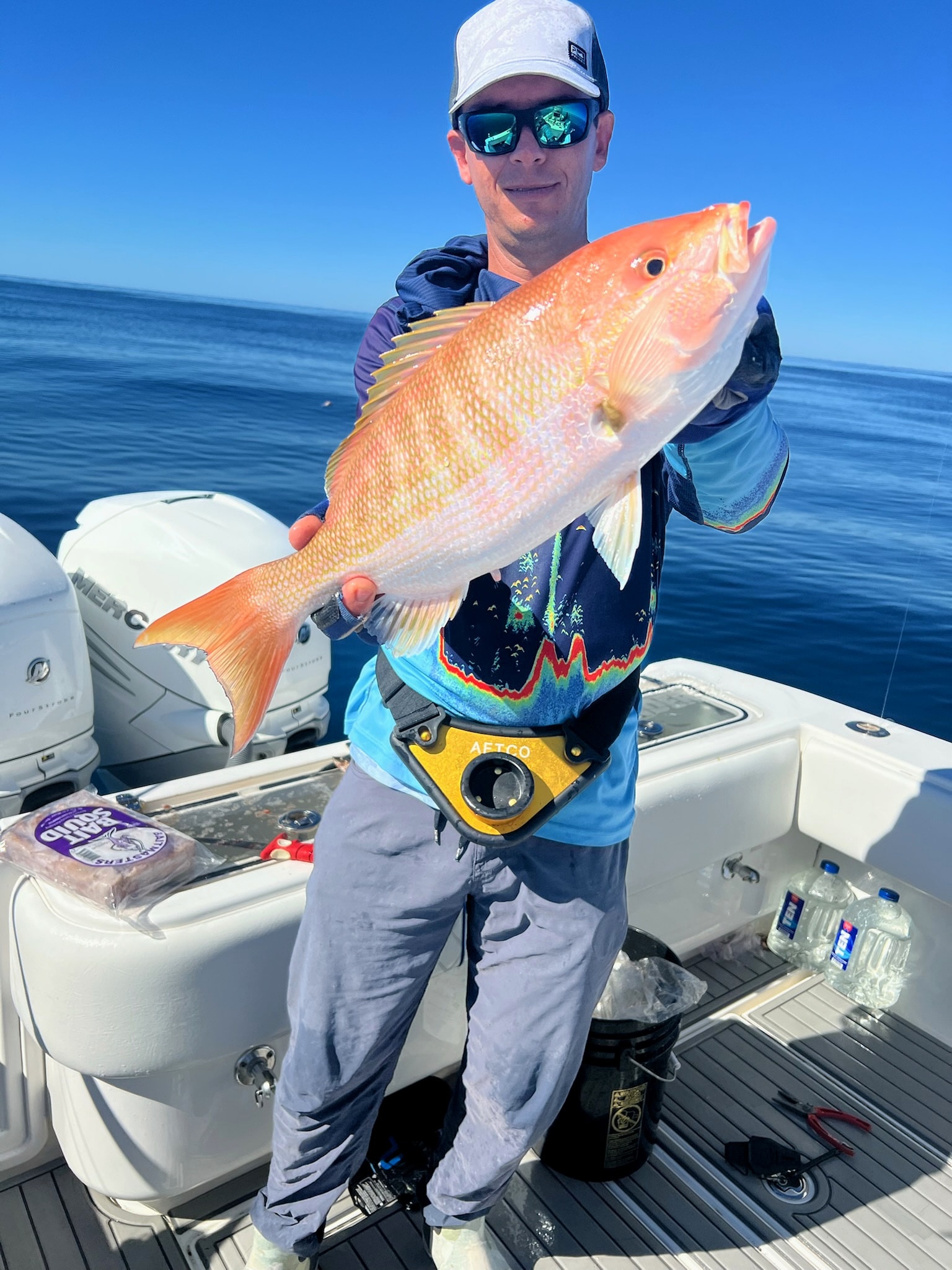 A trophy mutton snapper held up on the deck